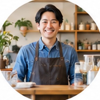 自分の店のカウンターに立つエプロン姿の男性