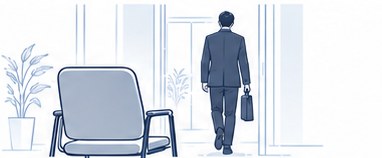 空いた椅子と、鞄を持って去っていく社員